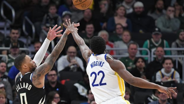 Milwaukee Bucks guard Damian Lillard (0) shoots the ball against Golden State Warriors forward Andrew Wiggins (22) 